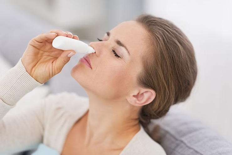 Frasco de spray descongestionante nasal sendo utilizado