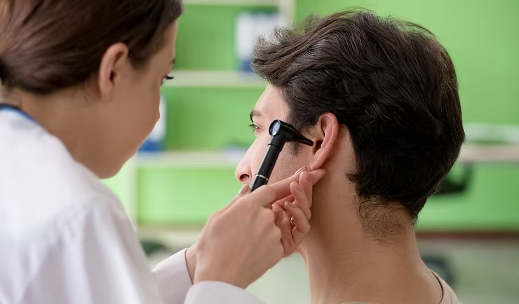 Médica otorrinolaringologista durante consulta, avaliando ouvido, nariz e garganta do paciente